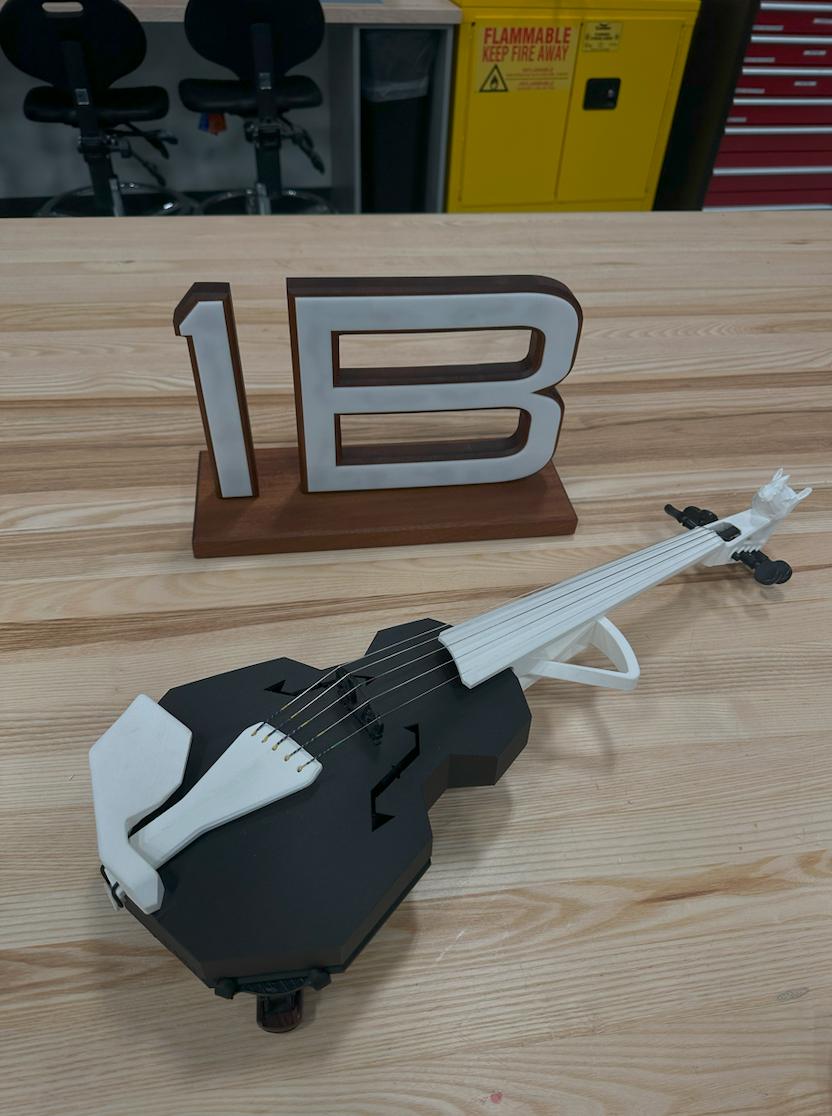 Project Music 3D printed black and white violin with 1B FirstBuild logo in background